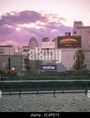 Nagoya, Aichi, Japan - Sakae, Innenstadt von Nagoya. Ein Riesenrad und Werbetafeln an Gebäuden. Stadtbild aus Oasis 21, eine moderne Anlage in Sakae. Stockfoto