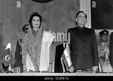 Der pakistanische Premierminister Benazir Bhutto, links, und der indische Premierminister Rajiv Gandhi stehen beim Beginn des vierten SAARC-Gipfeltreffens am 29. Dezember 1988 in Islamabad, Pakistan, zusammen. Zu den Treffen der Staats- und Regierungschefs Südasiens gehören Pakistan, Indien, Bangladesch, die Malediven, Sri Lanka, Bhutan und Nepal. Stockfoto