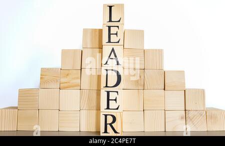 Der Text Führer auf Holzwürfel, im Hintergrund der Tassen . Nahaufnahme. Stockfoto