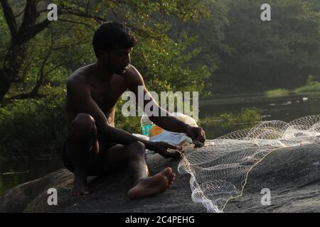 Mann, der ein Fischernetz zusammennäht Stockfoto