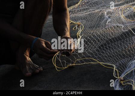 Mann, der ein Fischernetz zusammennäht Stockfoto