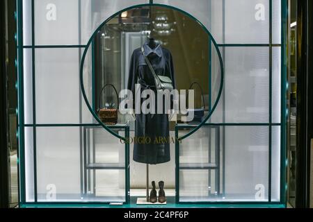 Mailand, Italien - 13. Januar 2020: Marineblauer Mantel in einer Giorgio Armani Vitrine bei Nacht Stockfoto