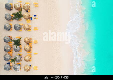 Antenne top Aussicht auf den Strand. Regenschirme, Sand und Meer Wellen Stockfoto