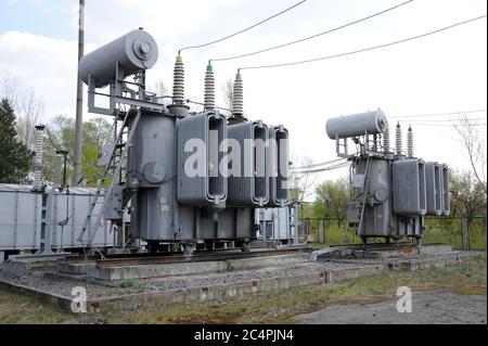 Transformator, Isolatoren und Teil der Hochspannungsleitungen der elektrischen Umspannstation Stockfoto
