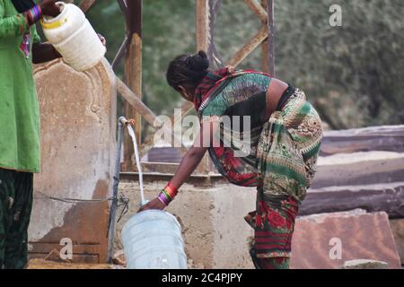 Eine arme Frau, die Wasser am Straßenrand von jaisalmer sammelt Stockfoto