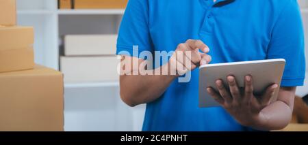 Das Versandunternehmen prüft die Paketliste vor der Lieferung an Kunden. Business Shipping and Delivery Service Konzept. Stockfoto