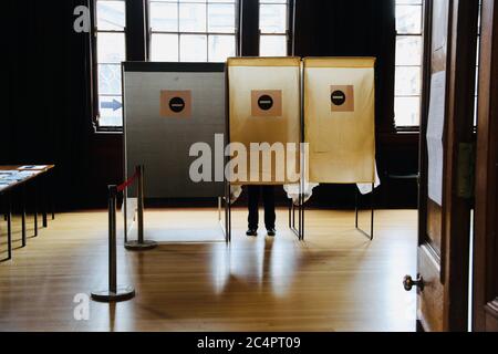 Ein Wähler in Abstimmung Stand auf einer Polling Station am Wahltag Stockfoto