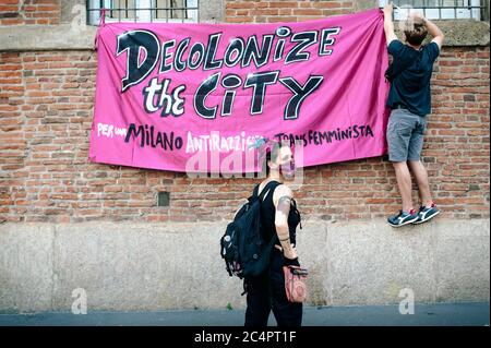 Mailand, Italien. Juni 2020. Aktivisten, die während der Demonstration ein Transparent aufsetzen, auf dem stand: "Dekolonisieren Sie die Stadt".die feministische Bewegung, nicht weniger (Non Una di Meno) Aufruf zu einer landesweiten Demonstration "Wasch nicht schmutzige Wäsche zu Hause!" Ziel der Demonstration ist es, die Bürger für häusliche Gewalt während der Covid-19-Sperre und weibliche wirtschaftliche und arbeitsrechtliche Diskriminierung zu sensibilisieren. Die Mailänder Abteilung von Not One Less hat eine öffentliche Versammlung auf dem Missori-Platz mit einer Broschüre über Gewalt durchgeführt. Kredit: Valeria Ferraro/SOPA Images/ZUMA Wire/Alamy Live Nachrichten Stockfoto