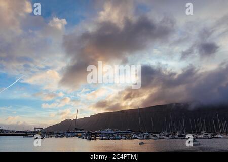 Der Hafen der Hauptsiedlung La Graciosa/Insel Graciosa, Caleta del Sebo, bei Tagesanbruch mit Blick auf Lanzarote, Kanarische Inseln, Spanien Stockfoto