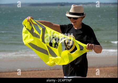 Southsea, Hampshire, England, Großbritannien. Juni 2020. Frau trägt soziale distanzierende T-Shirt und halten Sie Ihre Distanz his vis Weste an einem windigen Tag am Strand ein Stockfoto