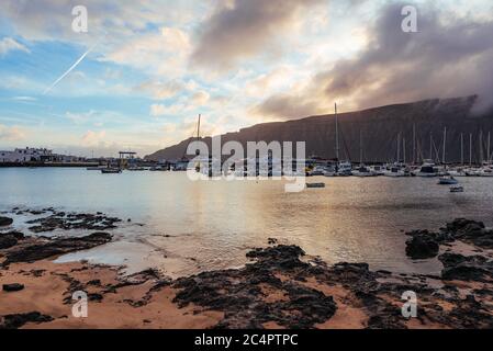 Der Hafen der Hauptsiedlung La Graciosa/Insel Graciosa, Caleta del Sebo, bei Tagesanbruch mit Blick auf Lanzarote, Kanarische Inseln, Spanien Stockfoto