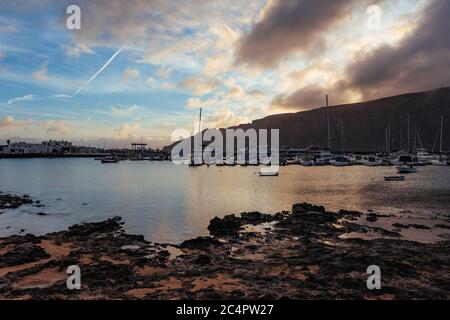 Der Hafen der Hauptsiedlung La Graciosa/Insel Graciosa, Caleta del Sebo, bei Tagesanbruch mit Blick auf Lanzarote, Kanarische Inseln, Spanien Stockfoto