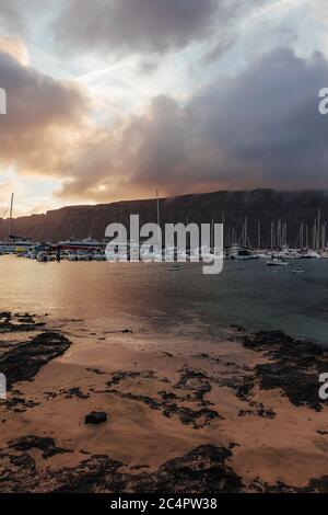 Der Hafen der Hauptsiedlung La Graciosa/Insel Graciosa, Caleta del Sebo, bei Tagesanbruch mit Blick auf Lanzarote, Kanarische Inseln, Spanien Stockfoto