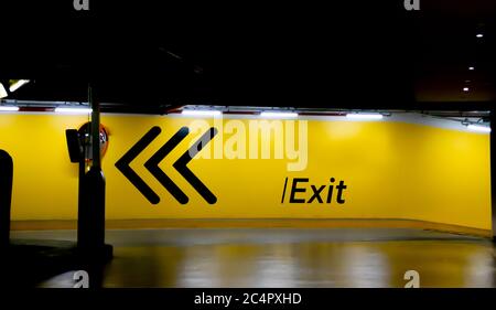 Schild mit dem Parkplatzausstieg an einer gelben Wandmalerei. Stockfoto