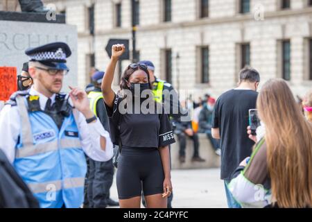 Die junge Protesterin hat ihr Foto von einer Freundin vor der Statue von Churchill bei einem Protest von Black Lives Matter in London gemacht Stockfoto