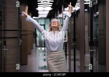 Glücklich aufgeregt erfolgreiche Senior Business Frau triumphiert im Büro Stockfoto