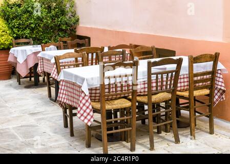 Straßencafé mit Pflanzen im Plaka-Viertel, Athen, Griechenland. Traditionelles griechisches Cafe für Touristen in Athen. Restaurant Tische im Freien in Athen Zentrum. Stockfoto