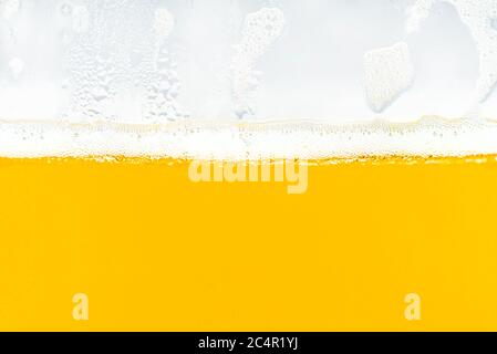 Makroaufnahme von Bier in einem Glas mit sichtbarem Schaum und Wassertropfen. Stockfoto