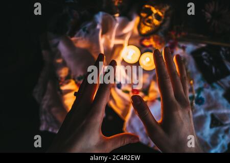 Hexerei Komposition mit brennenden Kerzen, Schmuck und Totenkopf. Stockfoto