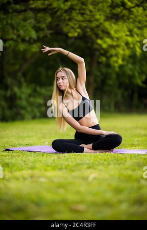 Stretching Frau in Outdoor-Sport-Übung. Lächelnd glücklich Yoga zu tun streckt nach dem Laufen. Stockfoto