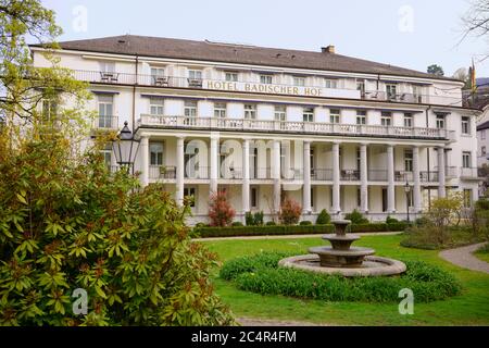 Hotel Badischer Hof in Baden-Baden, Deutschland. Historische Architektur mit dem Wahrzeichen der Stadt: Dem Thermalwasser-Dreischalenbrunnen. Stockfoto