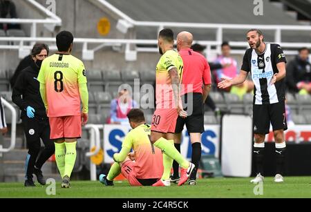 Andy Carroll von Newcastle United (rechts) zeigt sich gegenüber Schiedsrichter Lee Mason, nachdem er während des FA Cup Viertelfinalmatches im St. James' Park in Newcastle auf Aymeric Laporte (Boden) von Manchester City herausgefordert wurde. Stockfoto