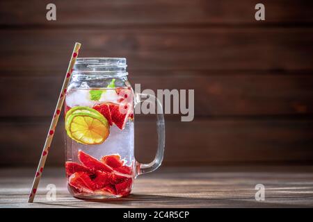 Fruchtwasser mit Limette, Zitrone und Erdbeere n Glasflasche. Gesunde Ernährung, Getränke, Ernährung und Entgiftungskonzept. Stockfoto