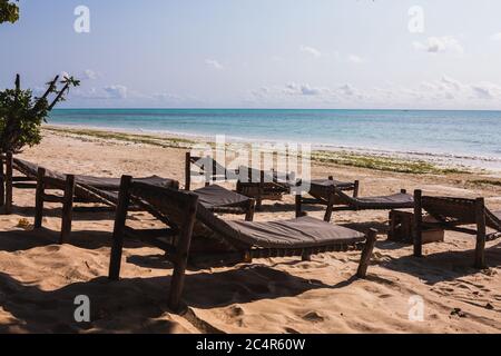 Eine Reihe leerer Liegen am Strand in Jambiani, Sansibar in Tansania Stockfoto