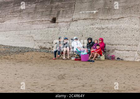 Garretstown, Cork, Irland. Juni 2020. Die Familien Coveney und Marron haben sich an einem kühlen Sommertag am Strand in Garrettstown, Co. Cork, Irland, eingepackt und geschützt. Die Coveney's sollten heute für ihren Familienurlaub nach Portugal fliegen, aber die Reise wurde wegen der Covid-19-Krise abgesagt. LtoR; Seán und Pat Coveney, Mary und Rory Marron, Niamh, Caitriona und Padraig Coveney schlossen sich an einem kühlen Sommertag am Strand in Garrettstown, Co. Cork, Irland, ein. - Credit David Creedon / Alamy Live News Stockfoto