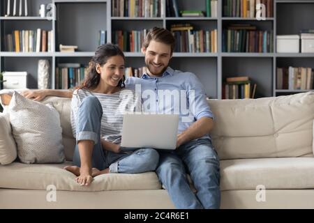 Lächelnde Frau und Mann umarmen, mit Laptop zusammen Stockfoto