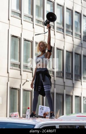 Eine Frau mit einem Megaphon steht auf dem Dach eines Transporters während einer Demonstration von Black Lives Matter, London, 20. Juni 2020 Stockfoto