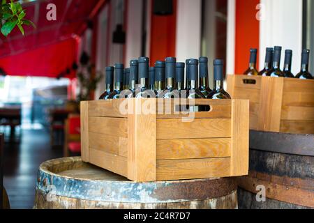 Eine Holzkiste mit Weinflaschen gefüllt. Bankfeier in einem Open-Air-Restaurant. Stockfoto