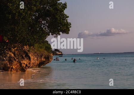 Ein großer Baum auf einer kleinen Felsklippe mit Blick auf den Indischen Ozean vom Nungwi Beach in Sansibar, Tansania bei Sonnenuntergang Stockfoto