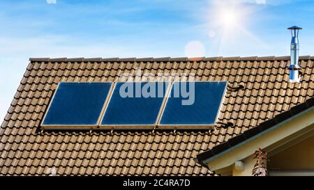Solarpanel auf dem Dach des Wohnhauses. Sonnensystem auf dem Dach der Nahaufnahme. Blaue Solarzellen auf der Gebäudeoberseite für alternative Energie. Fotovoltaik Stockfoto