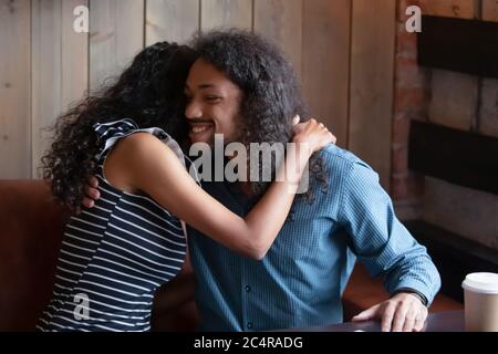 Afrikanisches Paar umarmt sitzen im Café während romantischen Date Stockfoto