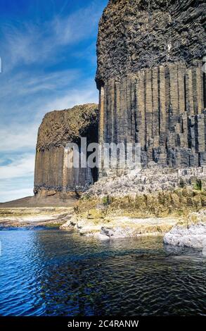 Hoch aufragende Meeresklippen aus sechseckigen Säulen aus Basaltsäulen auf der abgelegenen Insel Staffa, Schottland, Großbritannien. Stockfoto