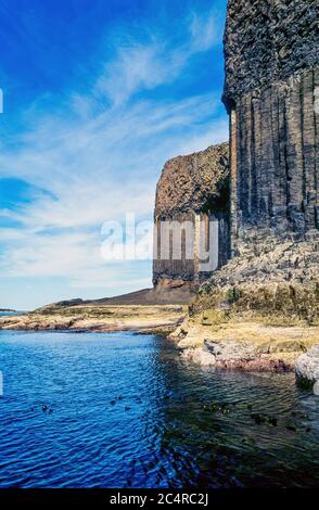 Hoch aufragende Meeresklippen aus sechseckigen Säulen aus Basaltsäulen auf der abgelegenen Insel Staffa, Schottland, Großbritannien. Stockfoto