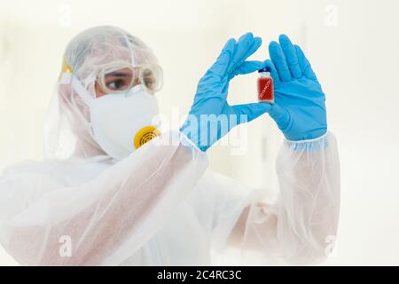 Mann in Schutzkleidung und Gasmaske auf weißem Hintergrund Stockfoto