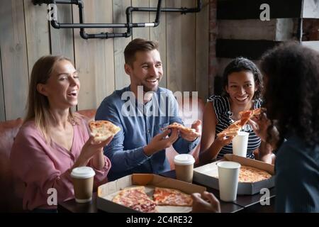 Vier multiethnische beste Freunde essen Pizza trinken Kaffee im Café Stockfoto