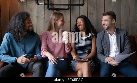 Multiethnische Kollegen ruhen sich in der Mittagspause im Café aus und unterhalten sich Stockfoto