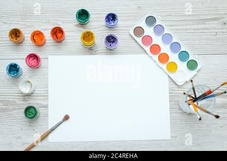 Werkzeuge für Zeichnung, Schreibwaren, Künstlerarbeitsplatz. Malen und Bleistifte und klares Papier auf Holztisch, Draufsicht, flaches Lay, Kopierraum. Schulzeichnung Stockfoto