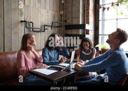 Freundliche Teamkollegen arbeiten sitzen im Café genießen Pause lustige Gespräche Stockfoto