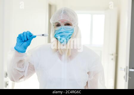 Forscher in schützende Schutzanzug ein Reagenzglas im chemischen Labor untersuchen. Stockfoto