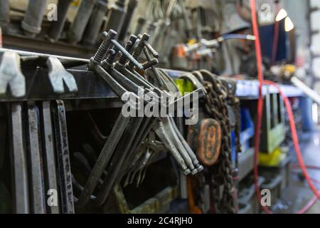 Betonwerk Fabrik Werkzeuge Lager Hintergrund, Crowbars und Stahl Klemmen in selektiver Fokusansicht mit verschwommenem Kopierraum auf der rechten Seite. Stockfoto