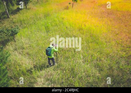 Tourist fotografieren der Natur auf einer dslr-Kamera auf Stativ während der Reise in der Natur. Draufsicht Stockfoto