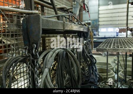 Betonwerk Fabrik Werkzeuge Lagerung Hintergrund, Pumpwerkzeuge, Hydraulikschläuche, Wasserleitungen, elektrische Drähte und Sicherheitsgitter. Stockfoto