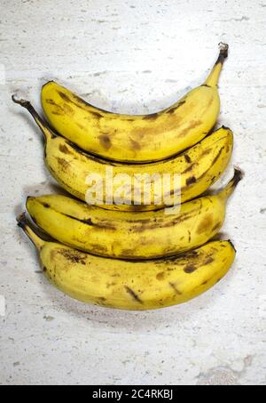 Vier reife Bananen auf einem Tisch Stockfoto