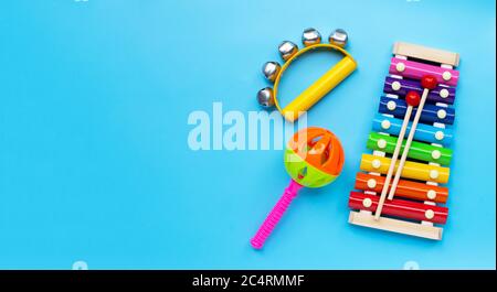 Handglocken Musikinstrument zum Klingeln mit buntem Xylophon und Babyrassel auf blauem Hintergrund. Speicherplatz kopieren Stockfoto