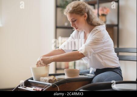 Die Hände eines Töpfers, erstellen ein irdenes Gefäß auf dem Kreis. Stockfoto