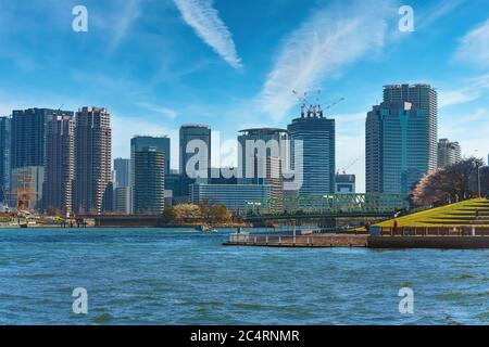 tokio, japan - april 04 2020: Ishikawajima Park gesäumt von Kirschblüten auf dem Sumida River vor der Aioi Brücke und Meiji Maru Segelboot mit Skys Stockfoto